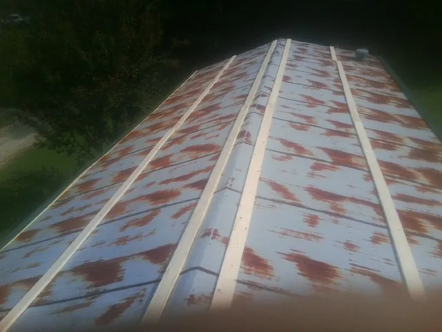 Rusted metal roof panels with new wood purlins before replacement — Storm Damage Roof Repair in Denison by Roofing Brothers