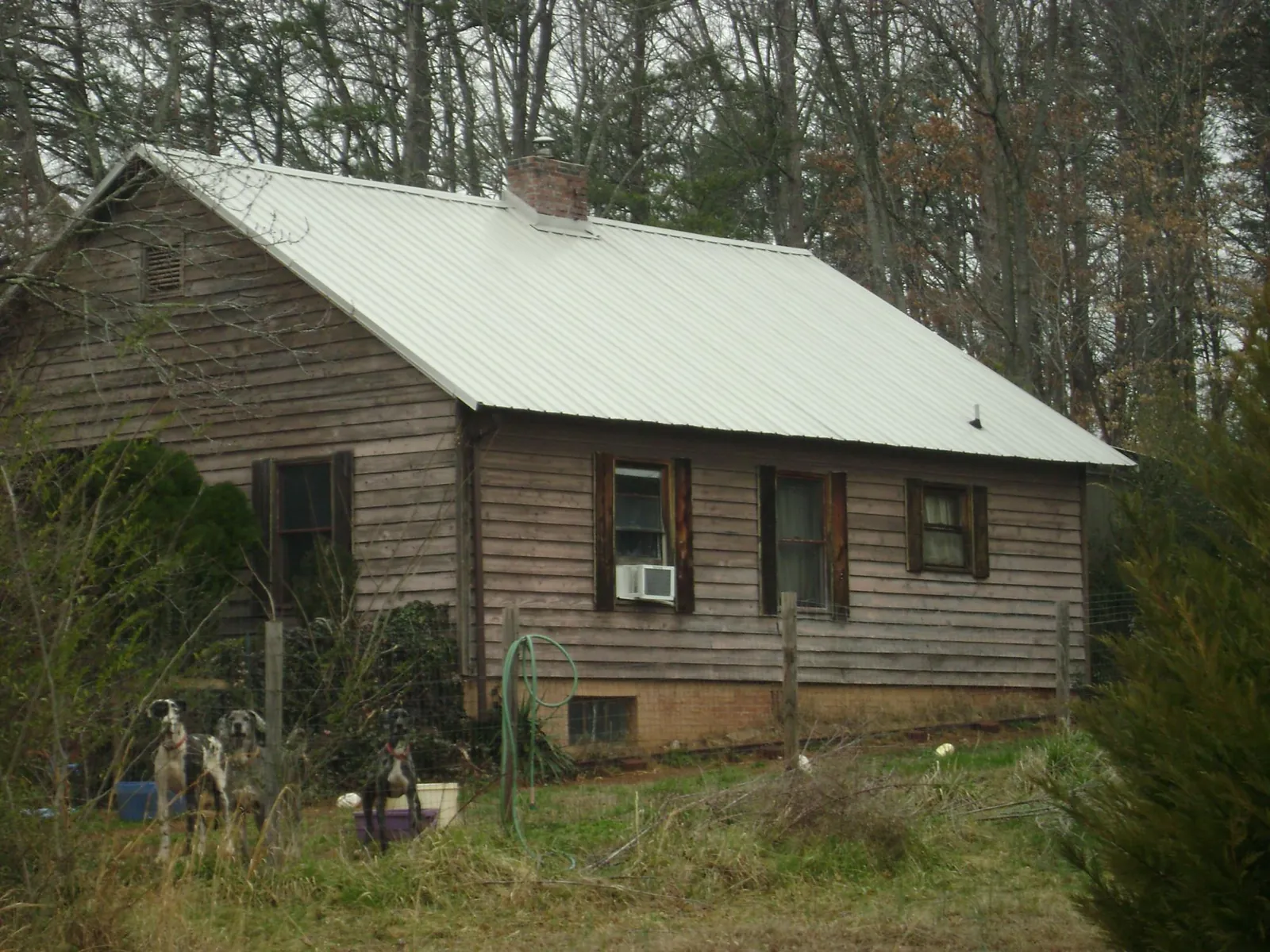 White metal roof on an old wood sided farmhouse, from a Metal Roof Installation job in Denison